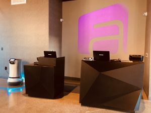 The Zenique Hotel projects their logo in purple behind the front desk. 