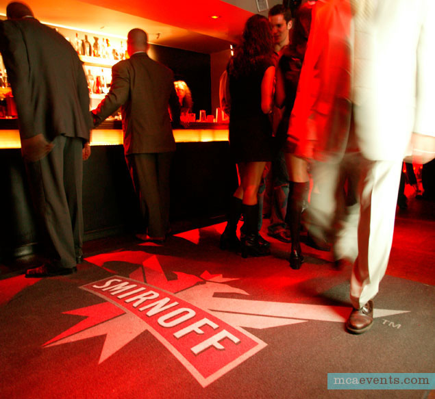 As people walk through a busy hotel bar, a motion sensor triggers the Smirnoff logo to project onto the floor.